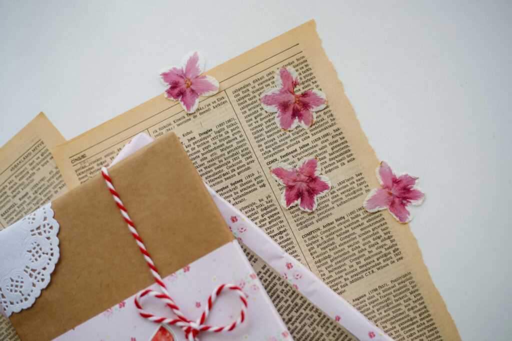 Retro styled papers and pink floral embellishments for crafting or decoration.