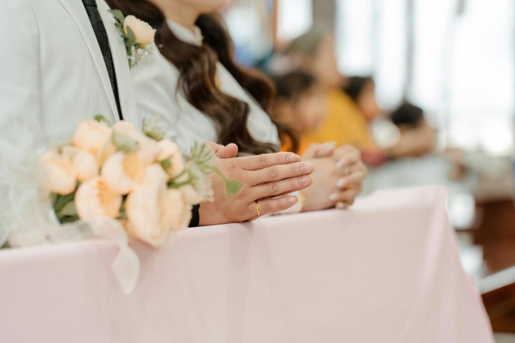 Close-up of a couple in a wedding ceremony holding a floral bouquet, highlighting details and emotions.