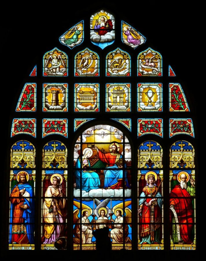 pexels-photo-6772979-6772979 Colorful stained glass window depicting saints and biblical scenes in a cathedral.