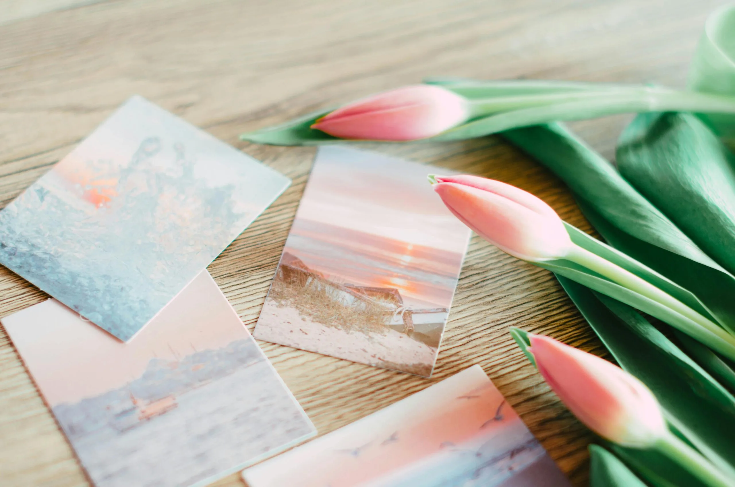 pexels photo 20251682 20251682 scaled Smallest of Seeds: Growing in Holiness in Daily Life Pink tulips and artistic postcards on a wooden table create a serene still life scene.
